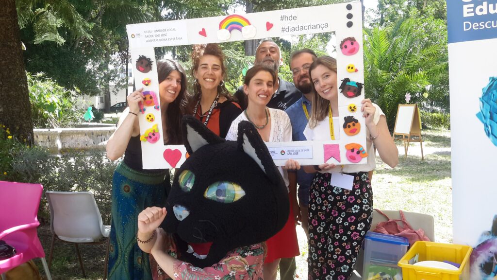 Pessoas numa moldura de selfie e uma pessoa com uma cabeça gigante de gato