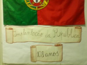 A bandeira de Portugal afixada no jornal de parede e o título Implantação da República, 108 anos.