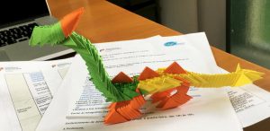 Um trabalho feito segundo a técnica de origami, representando um dragão articulado, composto por inúmeras pequenas peças que se encaixam.