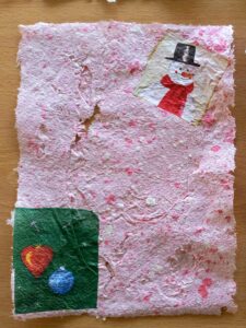 Uma folha de papel com motivos de Natal incorporados.