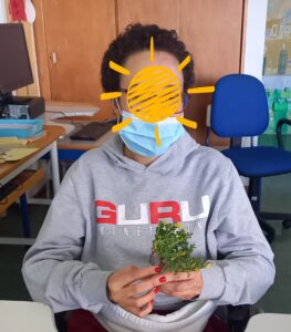 Uma aluna a sentir uma das plantas.