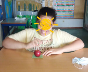 Uma aluna sorridente fala da sua maçã: as suas características e o que a levou a encontrá-la no meio de tantas outras.