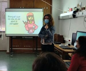 A mediadora cultural dá a sua aula de História com a ajuda do quadro interativo: por que razão é feriado no dia 25 de abril em Portugal?
