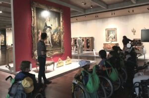 Durante a visita, em frente a um dos quadros que representa o retrato de Luís XIV. O mediador cultural Ricardo explica pormenores aos alunos.