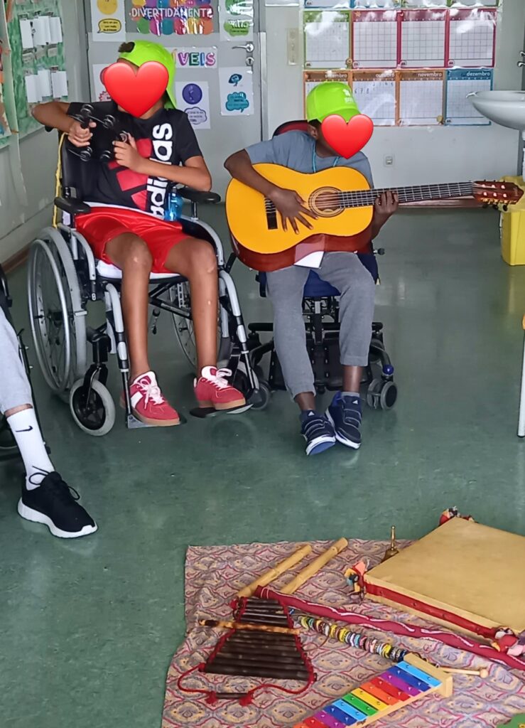 Dois alunos experimentam instrumentos musicais como a guitarra e a pandeireta.
