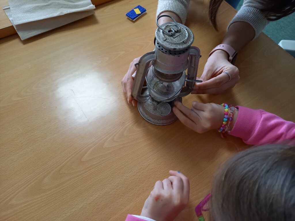 Crianças a decorarem um pequeno farol