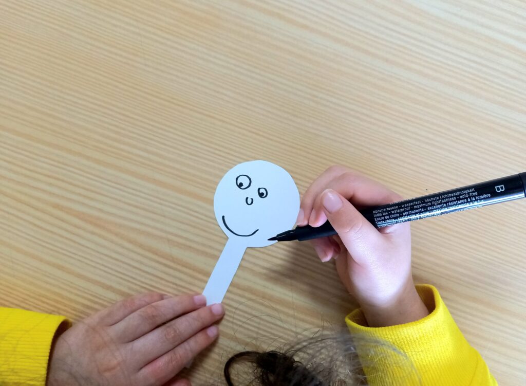 Criança a pintar um recorte de papel