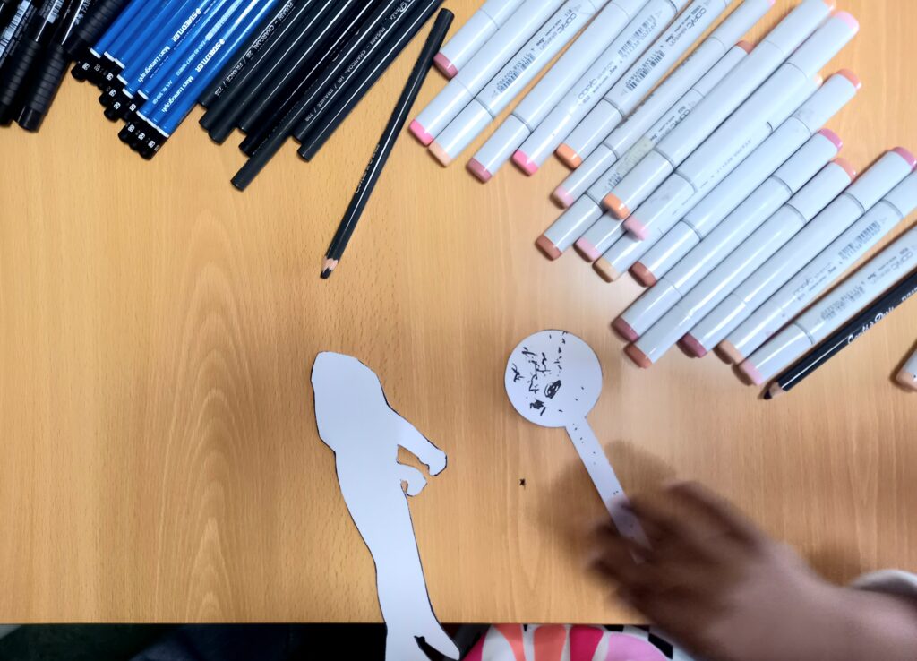 Recortes de papel, canetas de cor e lápis