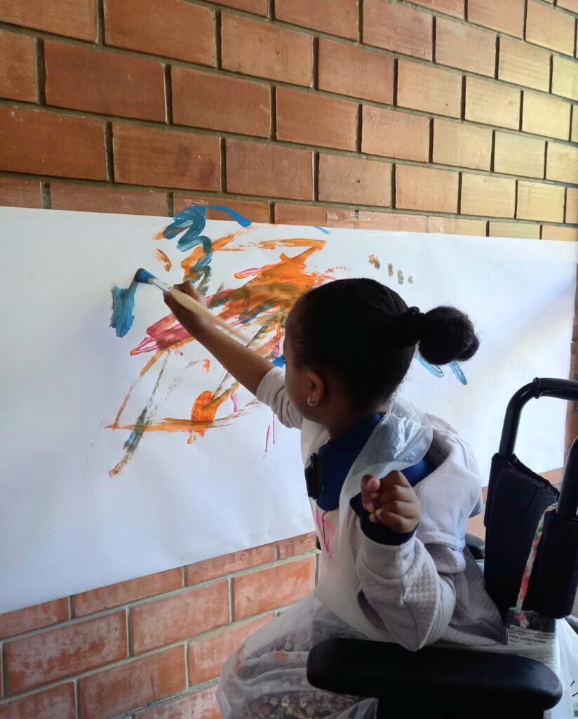 Criança pinta mural